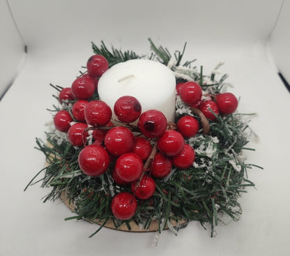 Decorative wreath with red berries and a white candle on a light background